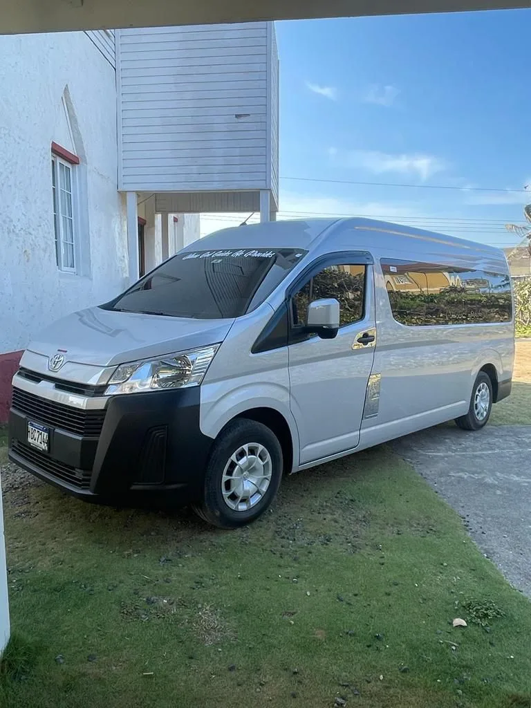 Van plateada estacionada para tours por la isla, Roatán